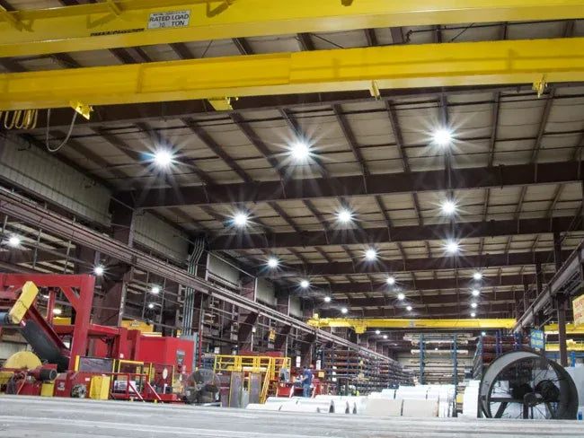 Large industrial warehouse with overhead cranes and equipment.
