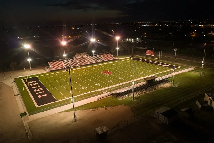 A football field at night with lights illuminating the area