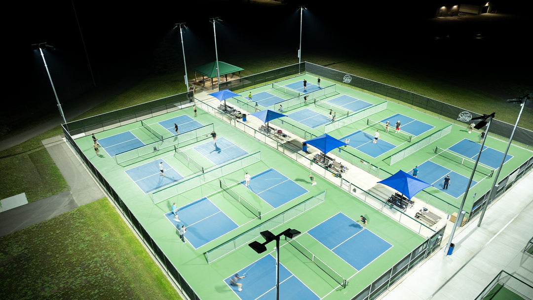 Pickleball courts at night with players on a well-lit court
