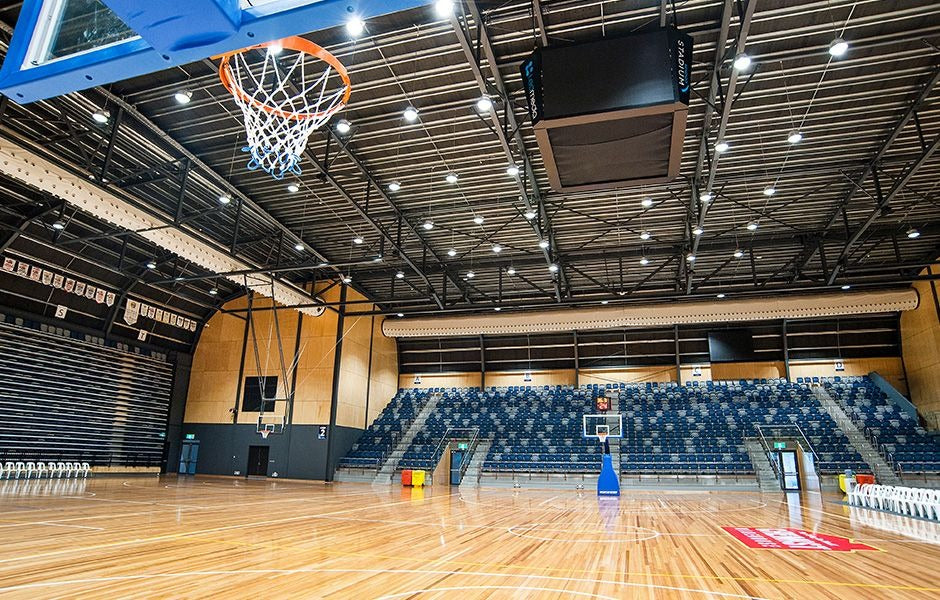Indoor basketball court with bleachers and sports equipment